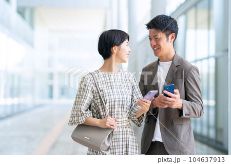 デートの時にスマホを操作する若い夫婦 104637913