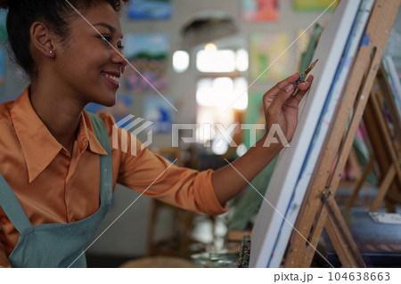 Beautiful american african artist woman painting in art studio at the university classroom Beautiful american african artist woman painting in art studio at the university classroom 104638663