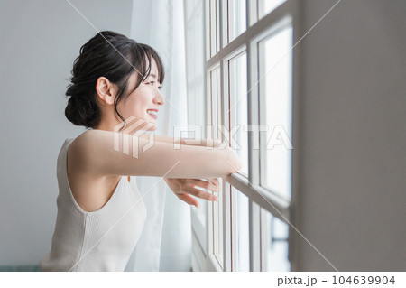 起きてカーテンを開けて朝日、日光を浴びる笑顔のアジア人女性 104639904