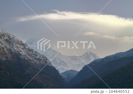 南アジアネパール　ヒマラヤトレッキングコースのウレリ村からアンナプルナサウスとヒウンチュリの頂と笠雲 104640552