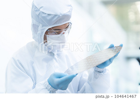 クリーンルームでウェハーを検査するエンジニア 104641467