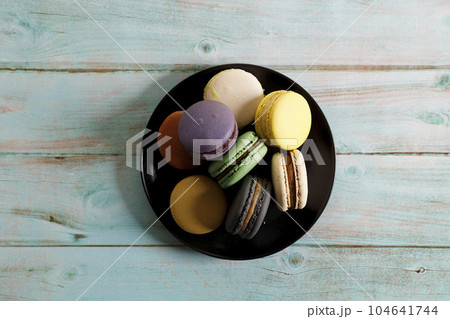 Colorful macaron cookies on black color plate. Sweet and colorful French macarons. 104641744