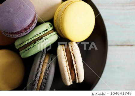 Colorful macaron cookies on black color plate. Sweet and colorful French macarons. 104641745