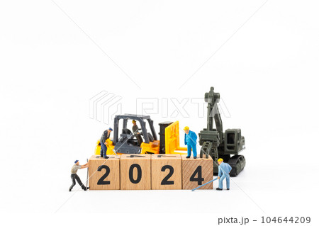 Miniature people , Worker team create a wooden block with the number 2024 104644209