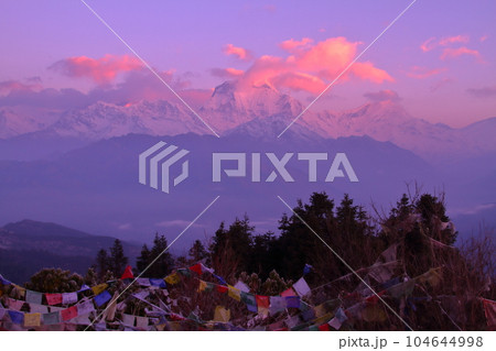 南アジアのネパール　ヒマラヤ山脈眺望の名所プーンヒルから夜明けのダウラギリ山群とタルチョーの景色 104644998