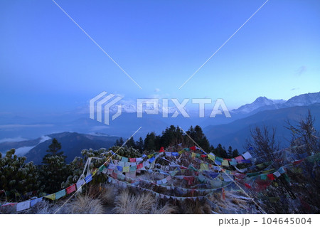 南アジアのネパール　ヒマラヤ山脈眺望の名所プーンヒルから夜明けのダウラギリ山群とタルチョーの景色 104645004
