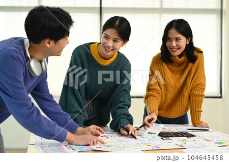 Image of mobile application designers team discussing, brainstorming for new approaches and ideas together Image of mobile application designers team discussing, brainstorming for new approaches and ideas together 104645458