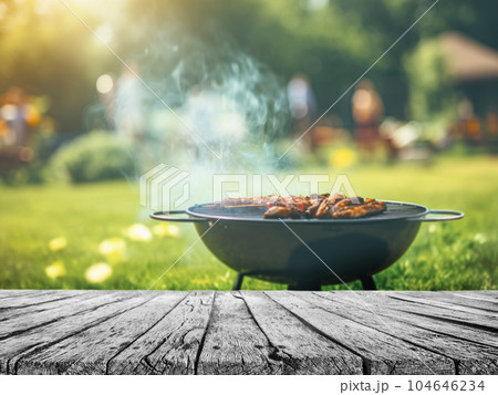 summer time in backyard garden with grill BBQ, wooden table, blurred background summer time in backyard garden with grill BBQ, wooden table, blurred background 104646234
