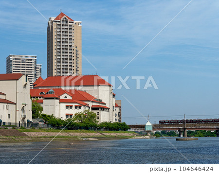 宝塚 宝来橋付近から見る宝塚大劇場と武庫川を渡る阪急電車 104646424
