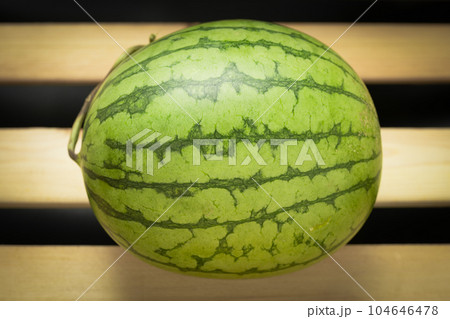 The watermelon placed on a wooden board. The watermelon placed on a wooden board. 104646478