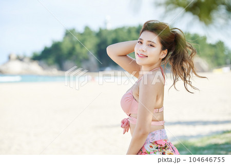 young woman in swimsuit posing on beach 104646755