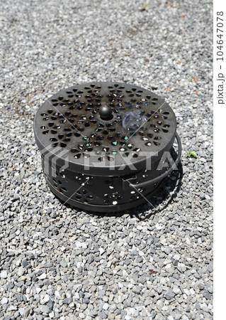 砂利敷きの地面に置かれた「蚊やり器」 砂利敷きの地面に置かれた「蚊やり器」 104647078