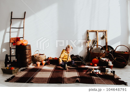 Cool trendy hipster boy 2 years old wears yellow jacket posing at the decorated photozone of autumn decor with beautiful bright autumn leaves. Cool trendy hipster boy 2 years old wears yellow jacket posing at the decorated photozone of autumn decor with beautiful bright autumn leaves. 104648791