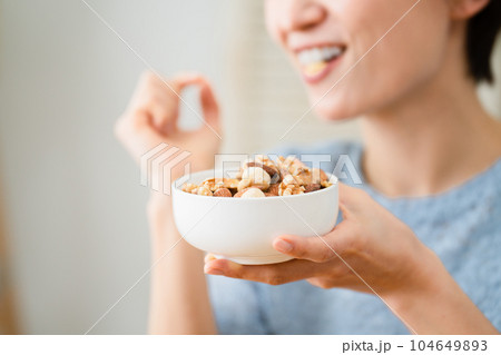 ミックスナッツを食べる若い女性　飲食イメージ 104649893