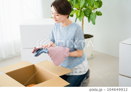段ボールから荷物を取り出す若い女性 引っ越しイメージ 段ボールから荷物を取り出す若い女性 引っ越しイメージ 104649912