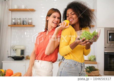 Multiracial Lesbian couple relaxing at home 104650317