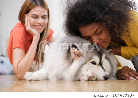 Multiracial Lesbian couple relaxing at home 104650337