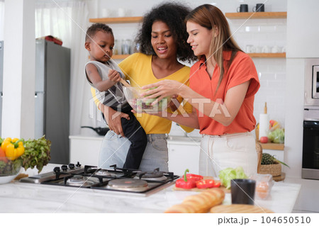 Multiracial Lesbian couple relaxing at home Multiracial Lesbian couple relaxing at home 104650510
