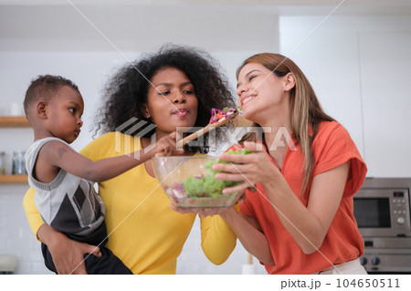 Multiracial Lesbian couple relaxing at home Multiracial Lesbian couple relaxing at home 104650511