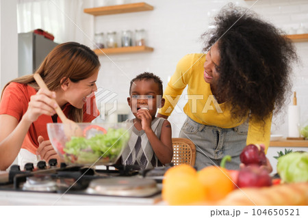 Multiracial Lesbian couple relaxing at home Multiracial Lesbian couple relaxing at home 104650521