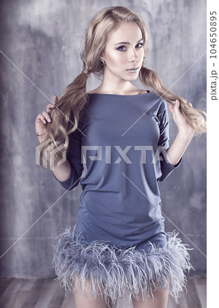Young and emotional woman in fashion dress over glamour background Young and emotional woman in fashion dress over glamour background 104650895