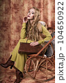 glamorous portrait of a beautiful young woman in a fur vest holding a bag 104650922