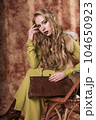 glamorous portrait of a beautiful young woman in a fur vest holding a bag 104650923