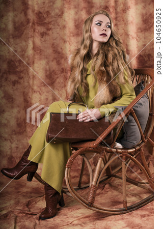 glamorous portrait of a beautiful young woman in a fur vest holding a bag 104650925