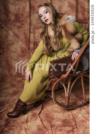 glamorous portrait of a beautiful young woman in a fur vest holding a bag 104650926