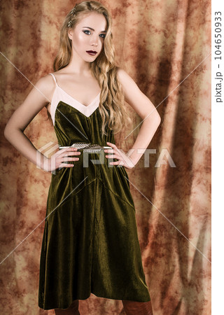 Beautiful fashion model in a velvet green dress. Vintage. Luxury style. Beautiful fashion model in a velvet green dress. Vintage. Luxury style. 104650933