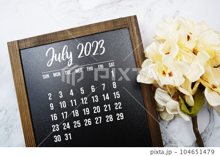 July 2023 monthly calendar with flower bouquet decoration on marble background 104651479