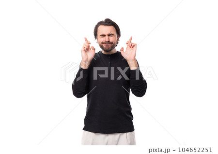 handsome brutal european macho man with black hair and beard with an earring in his ear crossed his handsome brutal european macho man with black hair and beard with an earring in his ear crossed his 104652251