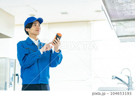 ポータブル測定器で室内環境を計測する作業員 104653193