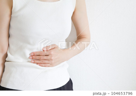 お腹を抑える女性　腹痛イメージ 104653796