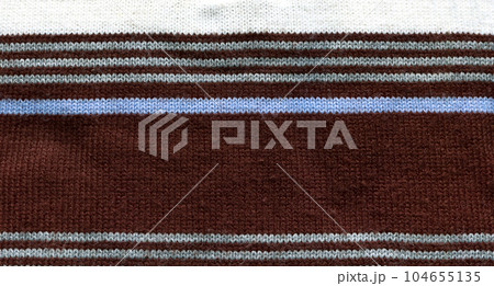 Handmade knitted fabric white brown and blue wool background texture Handmade knitted fabric white brown and blue wool background texture 104655135