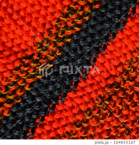 Handmade knitted fabric red and navy blue wool background texture Handmade knitted fabric red and navy blue wool background texture 104655187