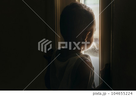 boy stood and looked out the window curiously 104655224