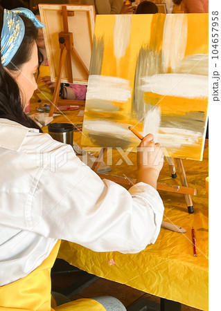 Woman with brush painting on canvas Woman with brush painting on canvas 104657958