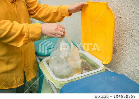 young woman throws garbage bag in the trash sorting waste, female in casual wear, eco-friendly person save planet, environment by pollution contamination. copy space. zero waste young woman throws garbage bag in the trash sorting waste, female in casual wear, eco-friendly person save planet, environment by pollution contamination. copy space. zero waste 104658568