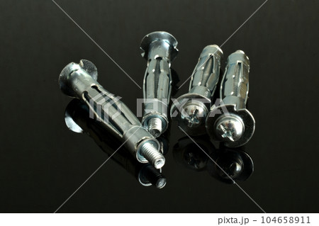 Anchor bolts for fastening on a black background. 104658911