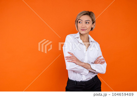 Confident woman wearing white official style shirt standing with crossed arms Confident woman wearing white official style shirt standing with crossed arms 104659489