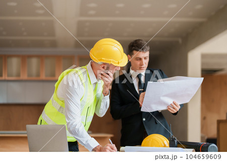 multi ethnic engineer brainstorming and measuring for cost estimating on blueprint and floor plan drawings about design architectural and engineering for houses and buildings. multi ethnic engineer brainstorming and measuring for cost estimating on blueprint and floor plan drawings about design architectural and engineering for houses and buildings. 104659609