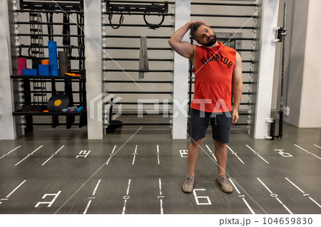 Athletic man warming up and stretching neck before training fitness gym, body care Athletic man warming up and stretching neck before training fitness gym, body care 104659830
