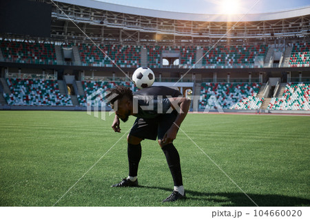 one football player is training holding the ball with his back 104660020