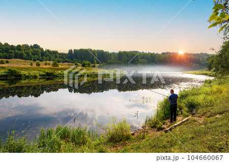 In the early summer morning, a fisherman is fishing in the upper reaches of the Volga River. 104660067