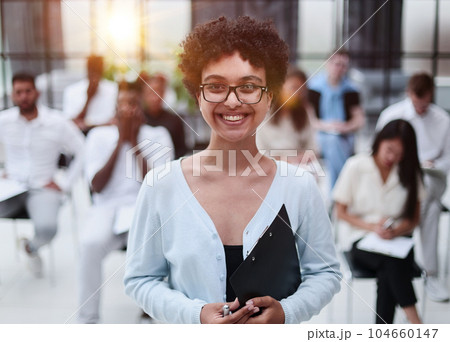 Happy businesswoman talking to her colleagues on seminar in the office. 104660147