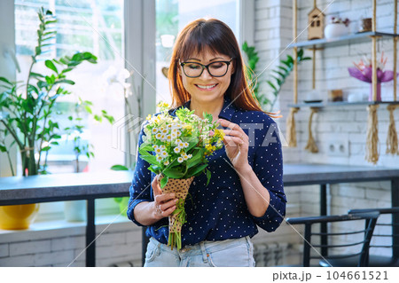 Portrait of middle aged smiling woman with bouquet of flowers 104661521