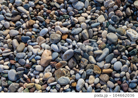 Smooth round pebbles texture background. Pebble sea beach close-up Smooth round pebbles texture background. Pebble sea beach close-up 104662036