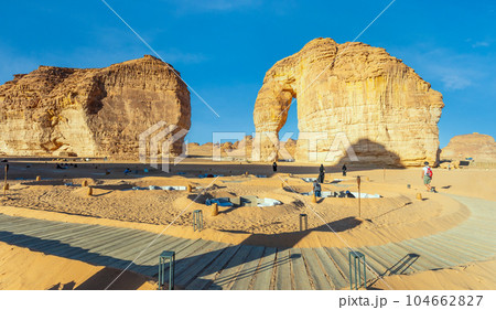 Walking tourist path and lounges at sandstone elephant rock erosion monolith standing in the desert, Al Ula, Saudi Arabia Walking tourist path and lounges at sandstone elephant rock erosion monolith standing in the desert, Al Ula, Saudi Arabia 104662827