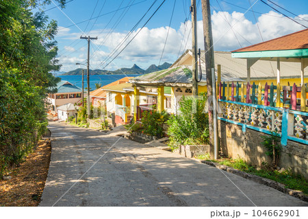 Colorful street with residential houses at the bay, of Mayreau island with Union island in the background, Saint Vincent and the Grenadines, West Indies, Caribbean Colorful street with residential houses at the bay, of Mayreau island with Union island in the background, Saint Vincent and the Grenadines, West Indies, Caribbean 104662901